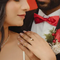 A close-up shot focusing on the bride's hand on the groom's chest, showcasing her engagement ring. A simple, elegant, and meaningful detail photo.