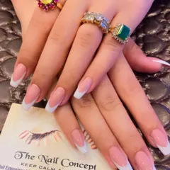 A beautiful, classic French manicure on long, square-shaped nails. The sheer pink base and bright white tips create a sophisticated and glamorous look.