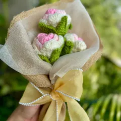 A delicate bouquet of pink and white tulip-style buds, wrapped in jute with a pearl-studded bow. It's a sweet and elegant arrangement.