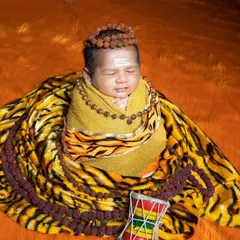 This newborn is smiling in his sleep, dreaming divine dreams as little Lord Shiva.