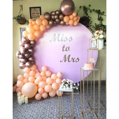 For the bride and her tribe, I create chic, photo-ready spaces. This popular 'Miss to Mrs' circular backdrop, paired with a custom peach and rose gold organic balloon arch, is perfect for a modern bridal shower.