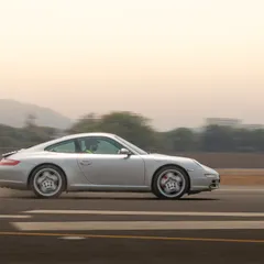 This panning shot of a silver Porsche 911 captures its classic lines while conveying a strong sense of speed and movement.