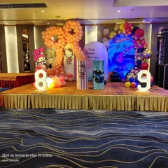 A full stage view of the dual-theme birthday party. This shows how I balance two different designs, Hello Kitty and Hot Wheels, using separate color schemes and backdrops while creating a cohesive look with light-up numbers for the ages.