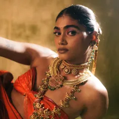For the 'Swaṟṇavalli' series, the goal was to create a look that felt both divine and powerful. I used a vibrant magenta eyeshadow to contrast with the traditional gold jewelry and kept the skin radiant and fresh. The sleek, adorned hairstyle completes this modern interpretation of a classic aesthetic.