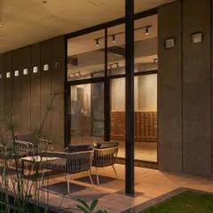 A closer view of the patio at 'The Earth' project. The exterior features a striking interplay of warm CSEB and grey granite, with sleek vertical grooves adding a contemporary touch to the earthy palette.