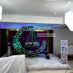 I love creating unique designs like this one for a naming ceremony. The centerpiece is a large crescent moon made of flowers, with a beautifully decorated floral cradle hanging in the center, creating a magical photo opportunity.
