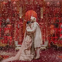 The Jaimala moment, where the couple is showered with petals inside the breathtaking 'Lal Bagh' setting. This is the culmination of months of planning, resulting in a moment of pure, unscripted joy.