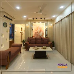A wide view of the living and dining area, showing how we integrated a comfortable lounge space with a chaise, a modern sofa set, and a dedicated wash basin area with decorative niches.