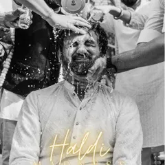The definition of "Haldi Madness." This black and white shot freezes a moment of pure, unadulterated fun as the groom gets drenched by his friends.