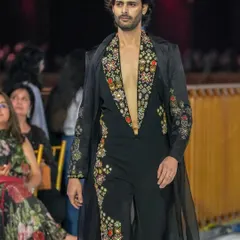 A runway shot of a male model in a stunning embroidered ensemble. My grooming work ensures the focus remains on the intricate details of the outfit while the model looks polished and confident.
