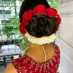 A closer look at a personalized floral bun. I love incorporating fresh flowers into my hairstyles. Here, I've combined red roses with a string of gajra to create a bold and traditional hair accessory for a classic bridal updo. This is a perfect example of a custom wedding hairstyle.