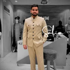 A client wearing a beige Jodhpuri-style suit with four front pockets. This safari-inspired design is a stylish and versatile option for various occasions.