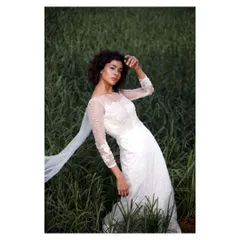 A different pose from the same editorial bridal shoot. The bride's gaze and the elegant lines of her gown create a look of quiet confidence and modern grace.