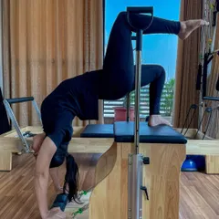 This client performs an advanced backbend on the Wunda Chair, a testament to her flexibility and strength. This equipment allows for unique movements that challenge the body in new ways.
