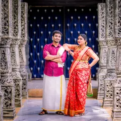 A confident and stylish pose by a couple in traditional South Indian attire. The ornate pillars create a powerful, symmetrical frame for this modern portrait.
