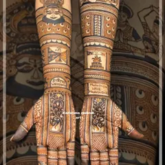 A unique "2 States" wedding theme brought to life through henna, blending cultures in one design. One arm features a detailed Kathakali mask representing the groom's Mallu heritage, while the other depicts traditional Marathi dancers for the bride, creating a beautiful narrative of their union.