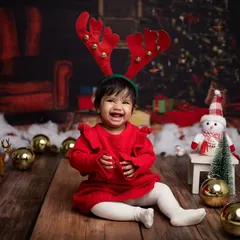 The reindeer antlers are on and she's all smiles! This is pure holiday cheer.