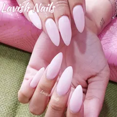 A simple yet striking set of long, stiletto-shaped nails in a soft, milky pink color.