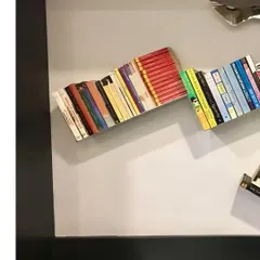 A throwback to a stainless steel bookshelf I designed many years ago. It creates the illusion of books floating on the wall.