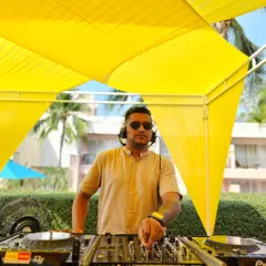 At the console under a bright yellow canopy for a daytime event in Hua Hin, Thailand. The vibe is sunny and relaxed, and the music reflects that.