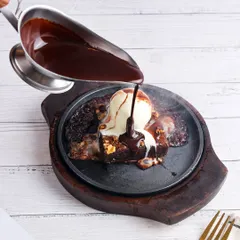 The ultimate indulgence: a sizzling brownie with melting ice cream and flowing chocolate sauce.