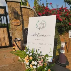 A custom welcome sign for a minimal wedding. The simple typography and delicate floral wreath design set a graceful and inviting tone for guests as they arrive at the Satori venue.