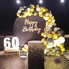The 60th birthday decoration seen with dramatic overhead lighting, highlighting the elegant color scheme.