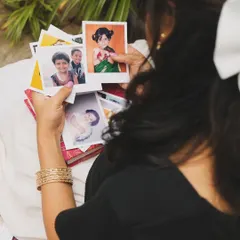 A behind-the-scenes photo from my music video shoot, looking at childhood pictures for inspiration. My music is often personal and drawn from real memories and emotions.