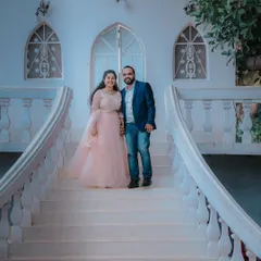 A classic pose on a sweeping white staircase. The couple's formal attire and the grand architecture make for a timeless and elegant pre-wedding photo.