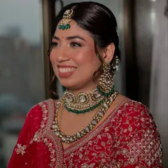 A classic Indian bride in red, looking absolutely timeless. I focused on creating that signature glass skin finish to make her complexion luminous, paired with a warm, earthy lipstick and defined eyes to make her smile the center of attention.