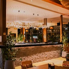 The bar at Botanica is a centerpiece of design, with its intricate leaf-patterned front and elegant lighting. It's the perfect spot to grab a cocktail and unwind.