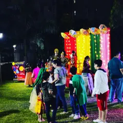 A stage setup for a performance during a society's dandiya night. The backdrop is colorful and lit with fairy lights, creating a focal point for the event's cultural activities.