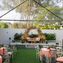 A wider view of the transparent tent setup for an engagement party, showing the combination of elegant table settings and a stunning floral stage, perfect for an evening under the stars.