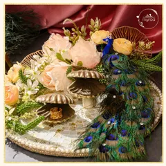 For engagements, I design platters that are as memorable as the moment itself. This piece, from my Ibtidaa collection, features a majestic peacock motif, delicate florals, and shell-shaped ring holders on a mosaic tray, creating a truly regal start to a new journey.
