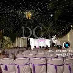 A wide view of an outdoor event space transformed by a canopy of fairy lights. This creates a magical, starlit atmosphere for guests to enjoy throughout the evening.