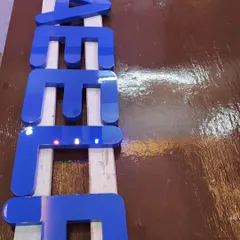 A close-up of the finished Duco-painted letters. The surface is so smooth and reflective you can see the light bouncing off it. This is the quality and attention to detail we bring to every Duco project.