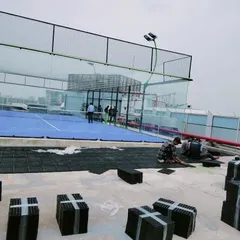 A view of the drain mat installation next to a rooftop padel court. This technical layer is essential before laying artificial turf or creating garden beds on a concrete slab.