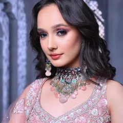 Elevating bridal beauty to new heights. This campaign shot features a stunning pink lehenga paired with a dramatic pink and black smokey eye and soft, open waves.