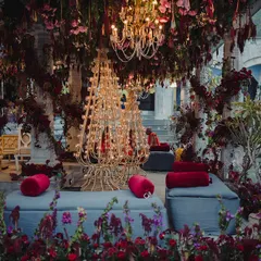 The lounge seating area for a traditional ceremony, surrounded by our elaborate floral decor. This shot captures the calm before the guests arrive, showing the intricate details like the custom candle stands and lush floor arrangements.