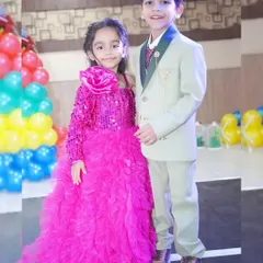 Two young siblings dressed in their party best for a birthday celebration.