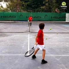 A young player practices his form during a coaching session. We focus on mastering the basics from an early age, ensuring every swing is a step toward brilliance.