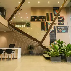 The reception area of this commercial space is designed to be open and welcoming. A dramatic staircase, graphic wall art, and comfortable seating create a strong first impression.