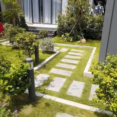 A geometric garden path using rectangular stone pavers set within a concrete frame and surrounded by lawn. This creates a structured and contemporary look.