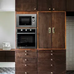 We design for real life. This tall unit in the Terrazzo Residence kitchen neatly integrates the oven and microwave, along with additional storage, ensuring a clean look and maximum efficiency.