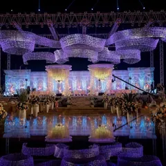 The entire venue bathed in a majestic purple light. This wide-angle view captures the full scale of the crystal reception stage, the reflective flooring, and the massive, ribbon-like installations we constructed overhead.