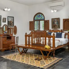 The Vasishta groom suite, with its own four-poster bed, rich wooden furniture, and elegant decor, providing a luxurious retreat.
