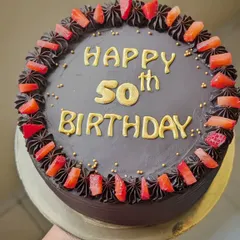 A delicious chocolate cake for a 50th birthday, topped with fresh strawberries for a perfect combination of flavors.