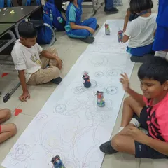 There's nothing like the excitement of seeing your own creation in action. These students are having a blast racing the scribbling bots they built and decorated themselves.