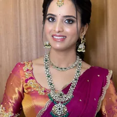 A smiling portrait of Chandana, showcasing her engagement makeup. I used a soft pink and gold palette on the eyes and a radiant base to complement her magenta and gold saree.