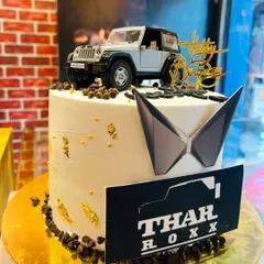 A side view of the silver Thar cake, showing the gold leaf accents and chocolate chip border.